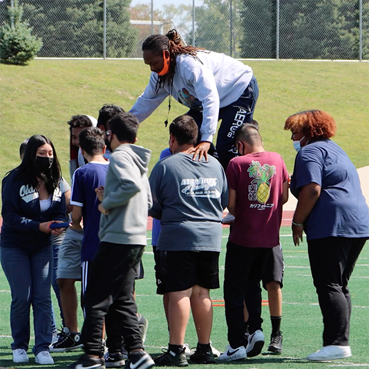  Students support a staff member walking across their arms